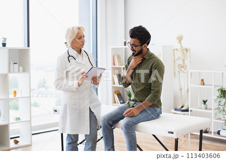 Gentleman describing symptoms of illness to senior female doctor. Gentleman describing symptoms of illness to senior female doctor. 113403606