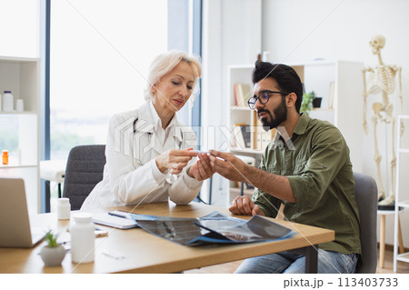 Gentleman describing symptoms of illness to senior female doctor. Gentleman describing symptoms of illness to senior female doctor. 113403733