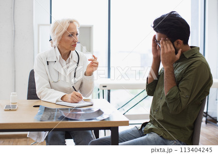 Man with headache listening to recommendations regarding medical history. 113404245