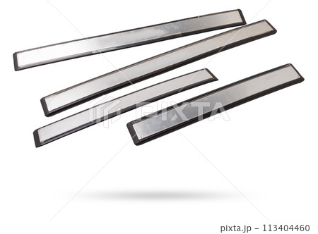 A four of black plastic decorative door sills in an automobile parsing for sale or repair in a workshop on a white isolated background in a photo studio. 113404460
