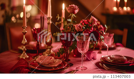 Festive table setting  with cutlery, candles and beautiful red flowers in vase 113407003