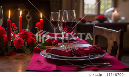 Festive table setting  with cutlery, candles and beautiful red flowers in vase 113407004