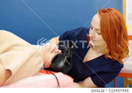 Woman with vertigo symptoms is on appointment of neurologist. Doctor making positional testing of patient with using VNG for determine type of dizziness. Epley maneuver Woman with vertigo symptoms is on appointment of neurologist. Doctor making positional testing of patient with using VNG for determine type of dizziness. Epley maneuver 113407448