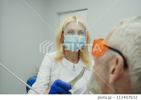 Male smiling during her dental treatment at dentist. 113407632