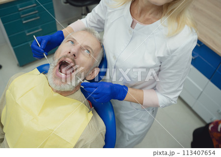 Male smiling during her dental treatment at dentist. Male smiling during her dental treatment at dentist. 113407654