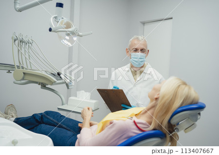 Woman smiling during her dental treatment at dentist. Woman smiling during her dental treatment at dentist. 113407667