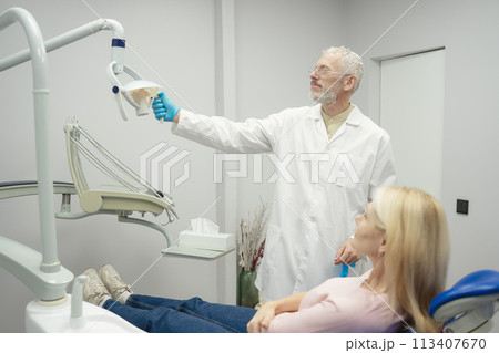 Woman smiling during her dental treatment at dentist. Woman smiling during her dental treatment at dentist. 113407670