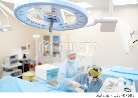 Surgeons are during maxillofacial operation using microscope and endoscope in modern hospital. Teamwork of doctors. Maxillofacial surgery. 113407695