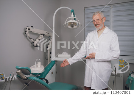 Portrait of attractive handsome dentist with haircut, white lab coat. 113407801
