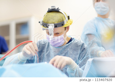 Surgeons are during maxillofacial operation using microscope and endoscope in modern hospital. Teamwork of doctors. Maxillofacial surgery. Surgeons are during maxillofacial operation using microscope and endoscope in modern hospital. Teamwork of doctors. Maxillofacial surgery. 113407920