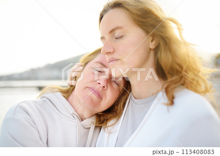 Cute woman tenderly hugs her mature mother on Mother's Day 113408083