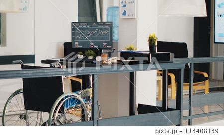 Wheelchair in inclusive accounting department office with forecasting profit analysis on laptop. Economic annual revenue trends on notebook in workspace with accessibility for workers, panning shot 113408139