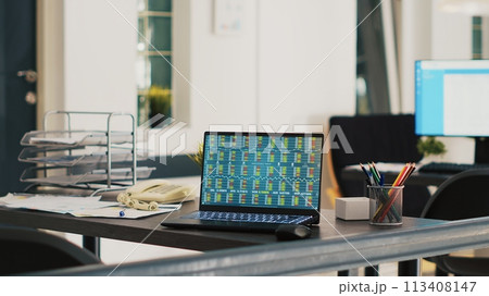 Company documents and laptop in financial department office showing stock exchange values. Business files on desk next to notebook showing forex trading indexes prices, panning shot Company documents and laptop in financial department office showing stock exchange values. Business files on desk next to notebook showing forex trading indexes prices, panning shot 113408147