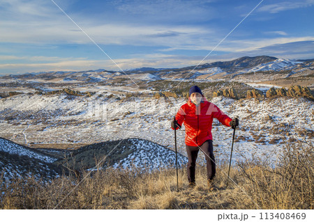 senior male hiker reaching top of a hill at foothills of Rocky Mountains - winter scenery at Devil's Backbone Open Space near Loveland, Colorado senior male hiker reaching top of a hill at foothills of Rocky Mountains - winter scenery at Devil's Backbone Open Space near Loveland, Colorado 113408469