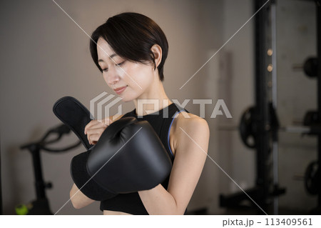 ジムでグローブを持つ女性　ボクシングやボクササイズのイメージ 113409561