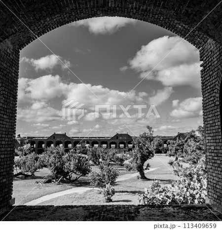 View through an open archway in Fort Jefferson on Dry Tortugas National Park with a the open courtyard a parade ground in the distance. View through an open archway in Fort Jefferson on Dry Tortugas National Park with a the open courtyard a parade ground in the distance. 113409659