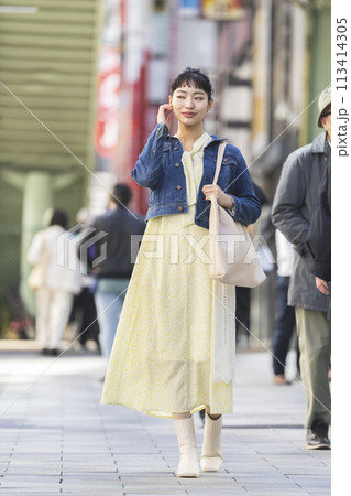 街を歩く若い女性 113414305