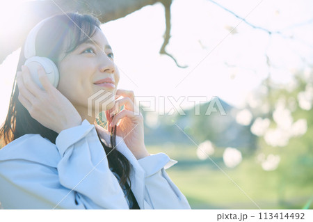桜の下で音楽を聴く女性 桜の下で音楽を聴く女性 113414492