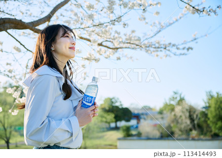 桜の下で清涼飲料水を飲む女性 桜の下で清涼飲料水を飲む女性 113414493