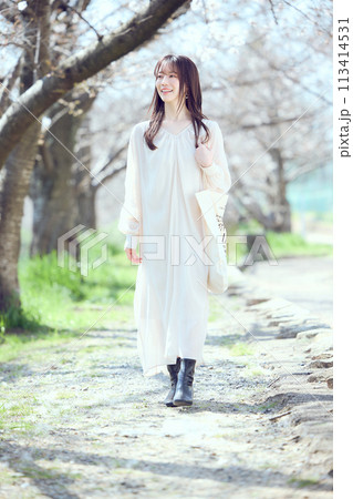 桜並木の河川敷を歩く女性 桜並木の河川敷を歩く女性 113414531