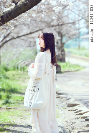 桜並木の河川敷を歩く女性 桜並木の河川敷を歩く女性 113414858