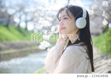 桜の下で音楽を聴く女性 113414936