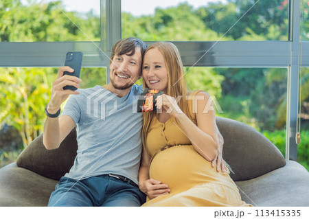 In a touching moment, the pregnant woman and father connect via video call, sharing the joy as they hold up an ultrasound photo, bridging the distance with the anticipation of their baby's arrival In a touching moment, the pregnant woman and father connect via video call, sharing the joy as they hold up an ultrasound photo, bridging the distance with the anticipation of their baby's arrival 113415335