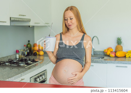 Happy pregnant young woman eating ice cream 113415604