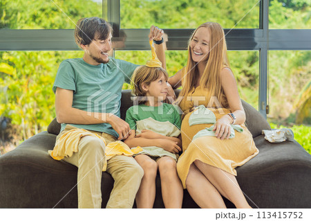 Heartwarming family moment as expectant mom, dad, and son joyfully browse through newborn baby's clothes, eagerly anticipating the arrival of a new family member Heartwarming family moment as expectant mom, dad, and son joyfully browse through newborn baby's clothes, eagerly anticipating the arrival of a new family member 113415752