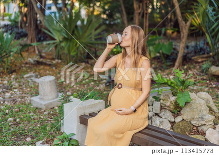 pregnant woman enjoys a cup of coffee outdoors, blending the simple pleasures of nature with the comforting warmth of a beverage during her pregnancy 113415778