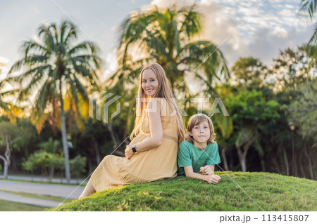 Heartwarming outdoor bonding as a pregnant mom and her son enjoy quality time together, savoring the beauty of nature and creating cherished moments 113415807