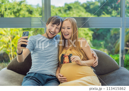 In a touching moment, the pregnant woman and father connect via video call, sharing the joy as they hold up an ultrasound photo, bridging the distance with the anticipation of their baby's arrival In a touching moment, the pregnant woman and father connect via video call, sharing the joy as they hold up an ultrasound photo, bridging the distance with the anticipation of their baby's arrival 113415862