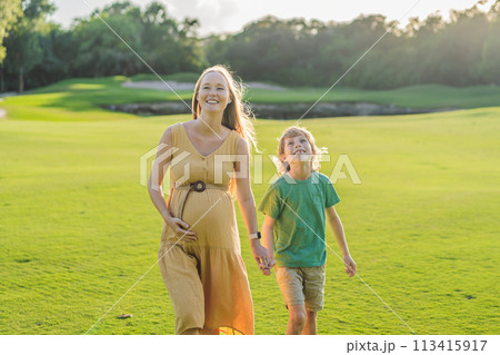 Heartwarming outdoor bonding as a pregnant mom and her son enjoy quality time together, savoring the beauty of nature and creating cherished moments 113415917