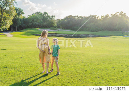 Heartwarming outdoor bonding as a pregnant mom and her son enjoy quality time together, savoring the beauty of nature and creating cherished moments 113415973