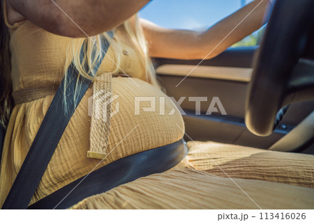 Pregnant woman driving with safety belt on in the car. Confident and capable, a pregnant woman takes the wheel, driving with care and determination as she navigates the journey of motherhood Pregnant woman driving with safety belt on in the car. Confident and capable, a pregnant woman takes the wheel, driving with care and determination as she navigates the journey of motherhood 113416026