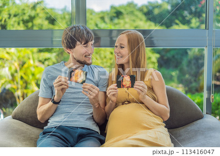 In a touching moment, the pregnant woman and father connect via video call, sharing the joy as they hold up an ultrasound photo, bridging the distance with the anticipation of their baby's arrival In a touching moment, the pregnant woman and father connect via video call, sharing the joy as they hold up an ultrasound photo, bridging the distance with the anticipation of their baby's arrival 113416047