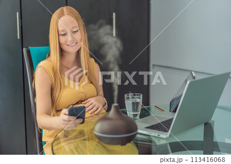 Expectant woman enhances work environment, using an aroma diffuser for a soothing atmosphere during pregnancy 113416068