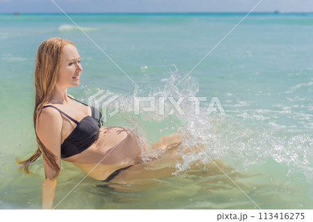 In the idyllic embrace of the Caribbean Sea, a pregnant woman finds bliss, savoring the warmth and serenity of the tropical waters during her pregnancy 113416275