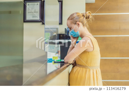 A pregnant woman stands at the hospital reception desk, embarking on a crucial phase of her maternity journey, seeking care and support in a healthcare setting A pregnant woman stands at the hospital reception desk, embarking on a crucial phase of her maternity journey, seeking care and support in a healthcare setting 113416279