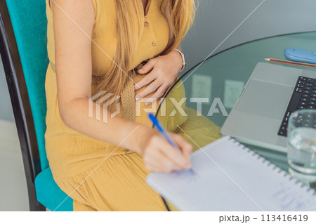 Beautiful pregnant woman working on laptop. Young businesswoman working in her office 113416419
