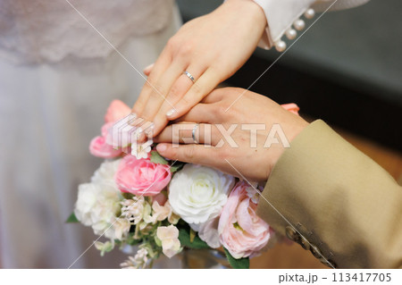 結婚指輪をはめた手を重ねる新郎新婦 結婚指輪をはめた手を重ねる新郎新婦 113417705