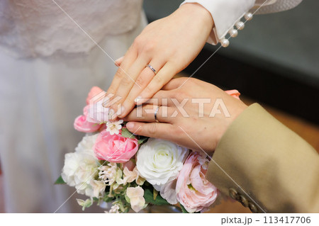 結婚指輪をはめた手を重ねる新郎新婦 結婚指輪をはめた手を重ねる新郎新婦 113417706