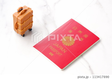 日本のパスポート(一般旅券10年用赤色)とスーツケースで、海外旅行に出かけるイメージ 日本のパスポート(一般旅券10年用赤色)とスーツケースで、海外旅行に出かけるイメージ 113417890