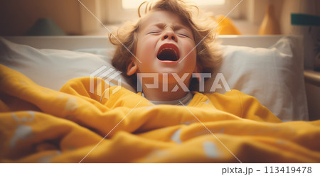Little sick child crying in bed in bedroom. 113419478