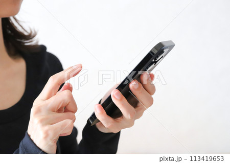 スマホを使う女性の手元 113419653
