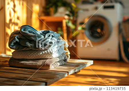 Washed clothes on board against background with washing machine in home laundry 113419735