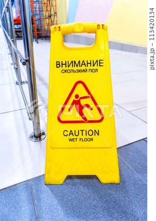 Caution Wet Floor warning sign on a tile floor in a superstore 113420134