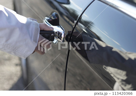 Hand holding car keys at door Hand holding car keys at door 113420366