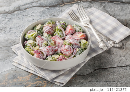 Broccoli salad with fresh strawberries, red onion, almonds and Greek yogurt close-up in a plate. Horizontal 113421275