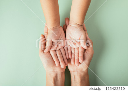 Top view of parents and kid holding empty hands isolated on a color background. Celebrating Family Day symbolizing togetherness and generational support. Top view of parents and kid holding empty hands isolated on a color background. Celebrating Family Day symbolizing togetherness and generational support. 113422210